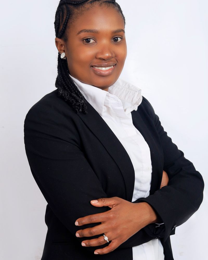 Placeholder portrait for Dania Beckford — confident businesswoman in a black suit; official photo to follow