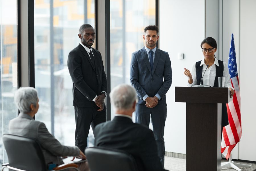 Speakers addressing an audience from a podium at a professional event